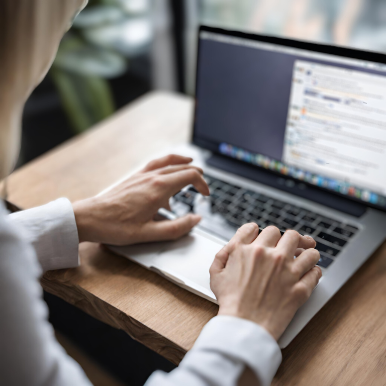 Woman typing on a laptop in an office setting